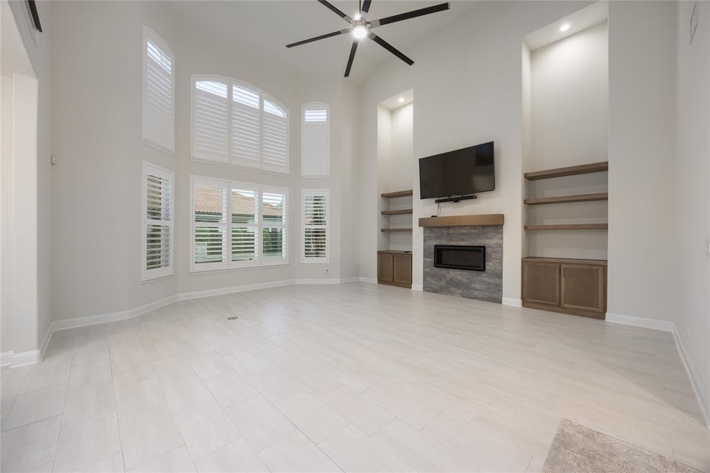 918 Sydney Lane Allen, TX 75013 - Photo 6 of 40 This spacious living area features high vaulted ceilings, light-colored flooring, and large windows with white shutters