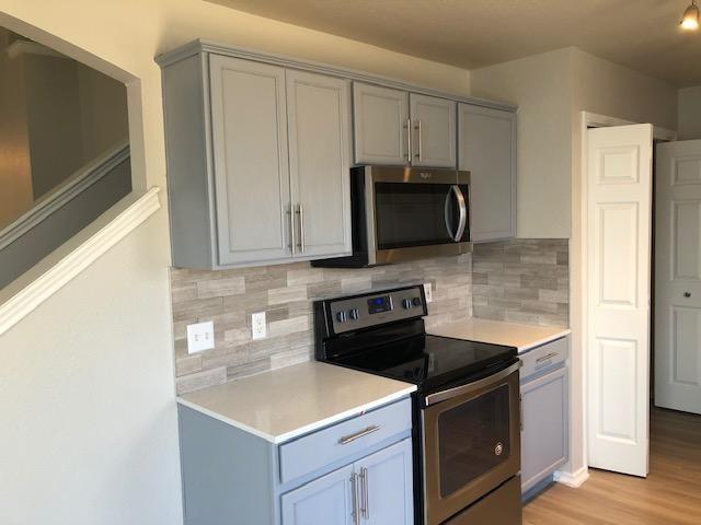 9217 Rowlands Sayle Road Austin, TX 78744 - Photo 5 of 18 Crisp stone counters pair beautifully with updated cabinetry and a modern tile backsplash.