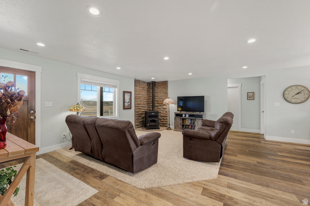 18573 South Marsh Valley Road Downey, ID 83234 - Photo 7 of 32 Living room with wood finished floors, a wood stove, and recessed lighting