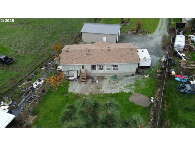 an aerial view of a house with a garden and lake view