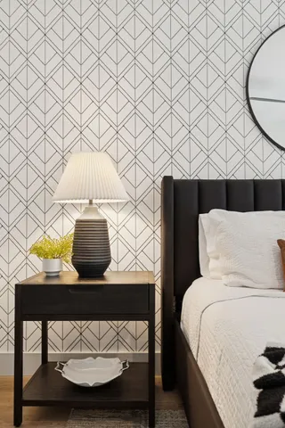 a bedroom with a bed and dresser with mirror