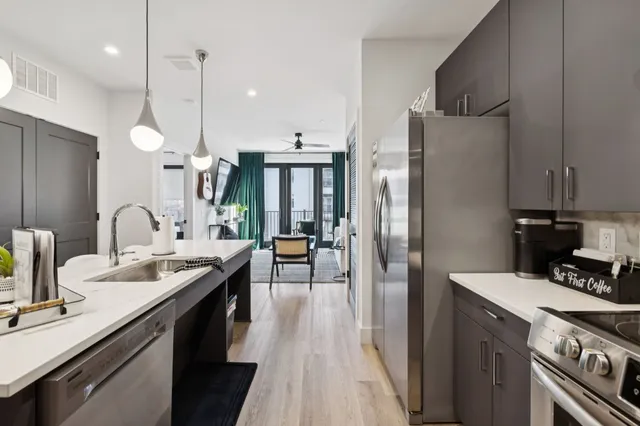 a kitchen with stainless steel appliances granite countertop a stove a refrigerator and a sink