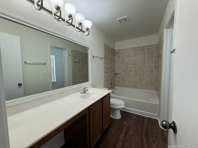 a bathroom with a tub a sink and a large mirror