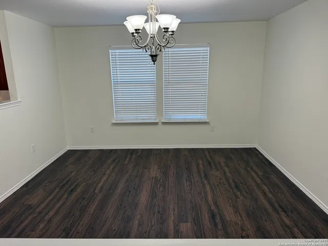 a view of wooden floor and a chandelier in a room