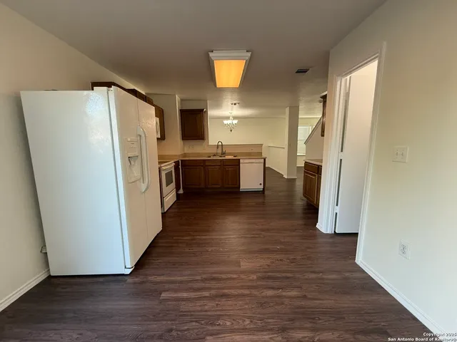 a kitchen with stainless steel appliances a refrigerator and wooden floor