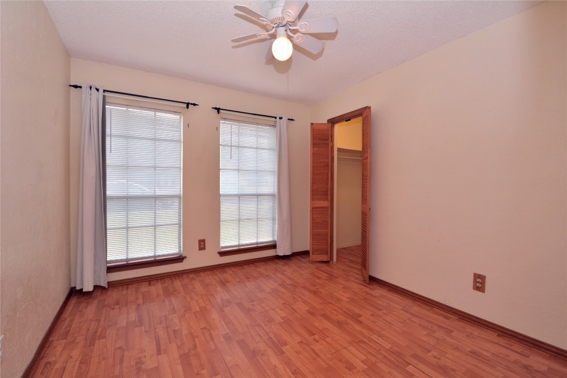 12327 Deerbrook Trail Austin, TX 78750 - Photo 14 of 20 an empty room with wooden floor cabinet and windows
