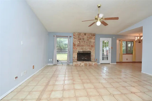 a view of an empty room with window and fireplace