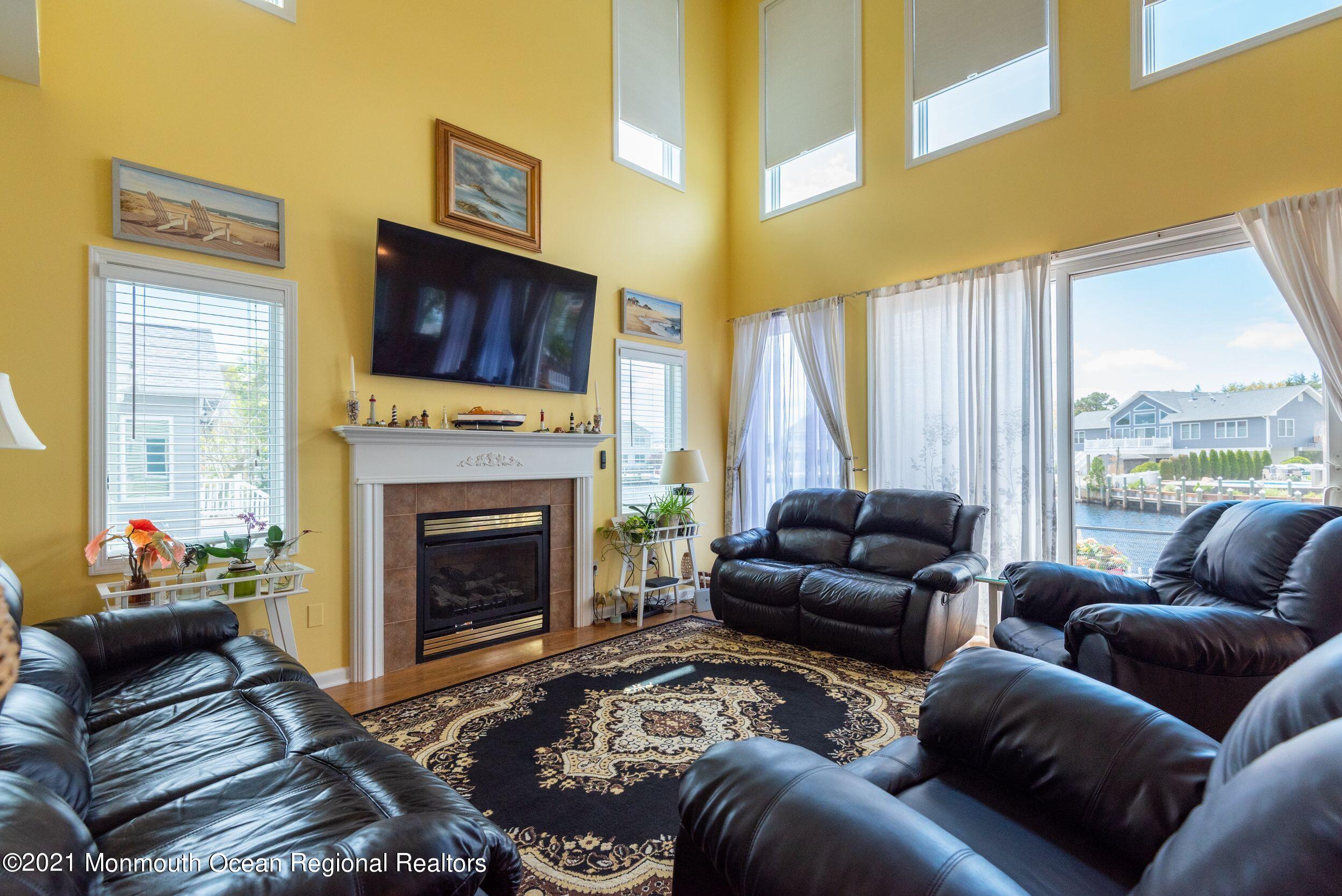 94 Cedar Run Road Bayville, NJ 08721 - Photo 18 of 43 a living room with furniture a large window and a fireplace