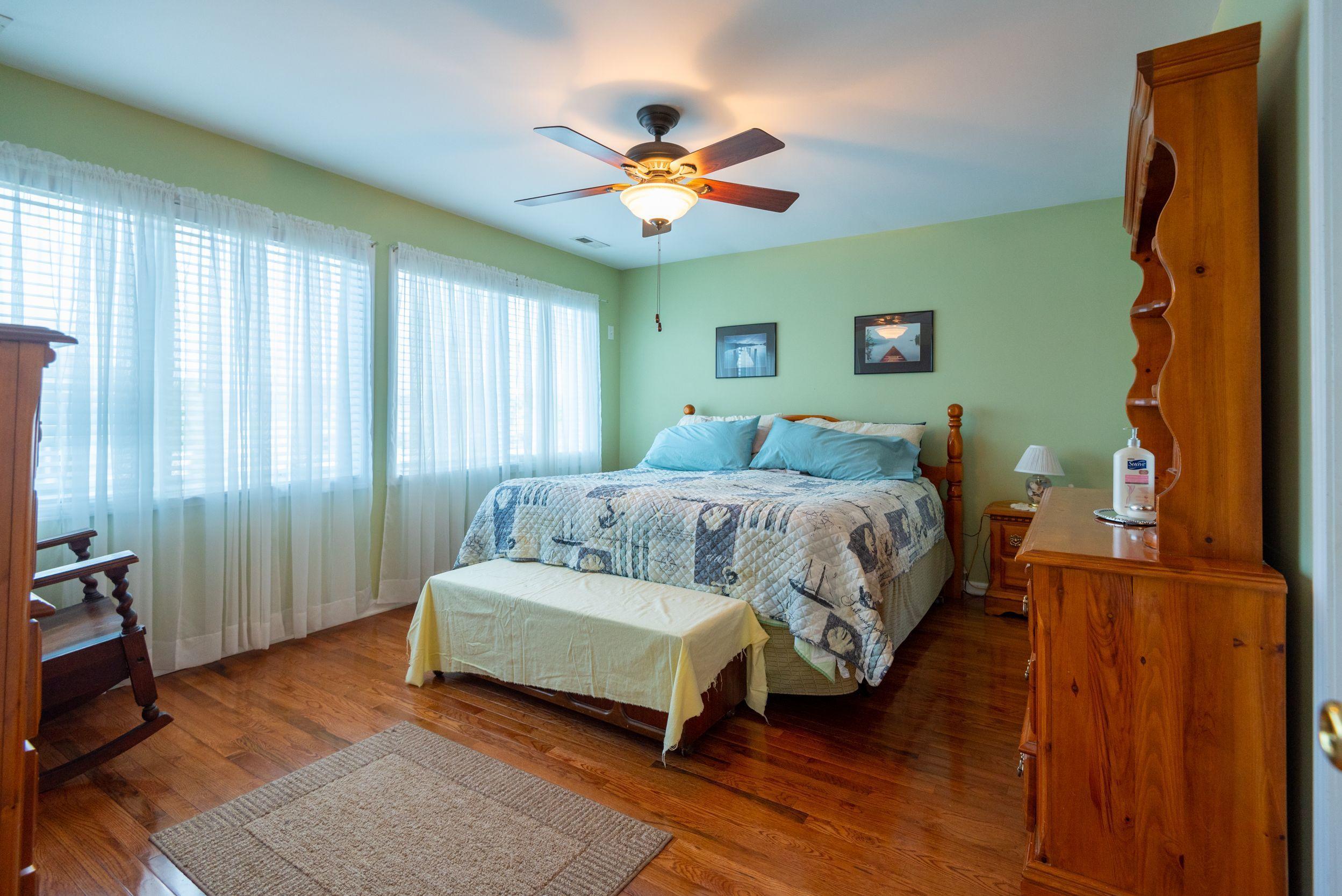 94 Cedar Run Road Bayville, NJ 08721 - Photo 24 of 43 a bedroom with a bed and a chandelier