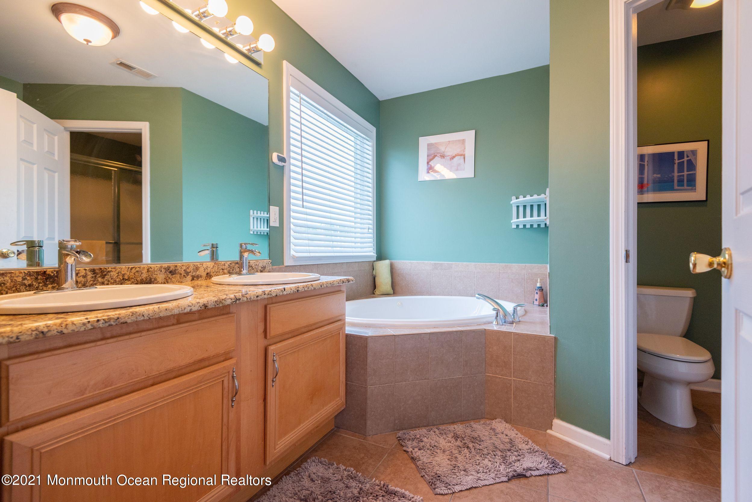94 Cedar Run Road Bayville, NJ 08721 - Photo 26 of 43 a bathroom with a granite countertop sink a toilet and a mirror