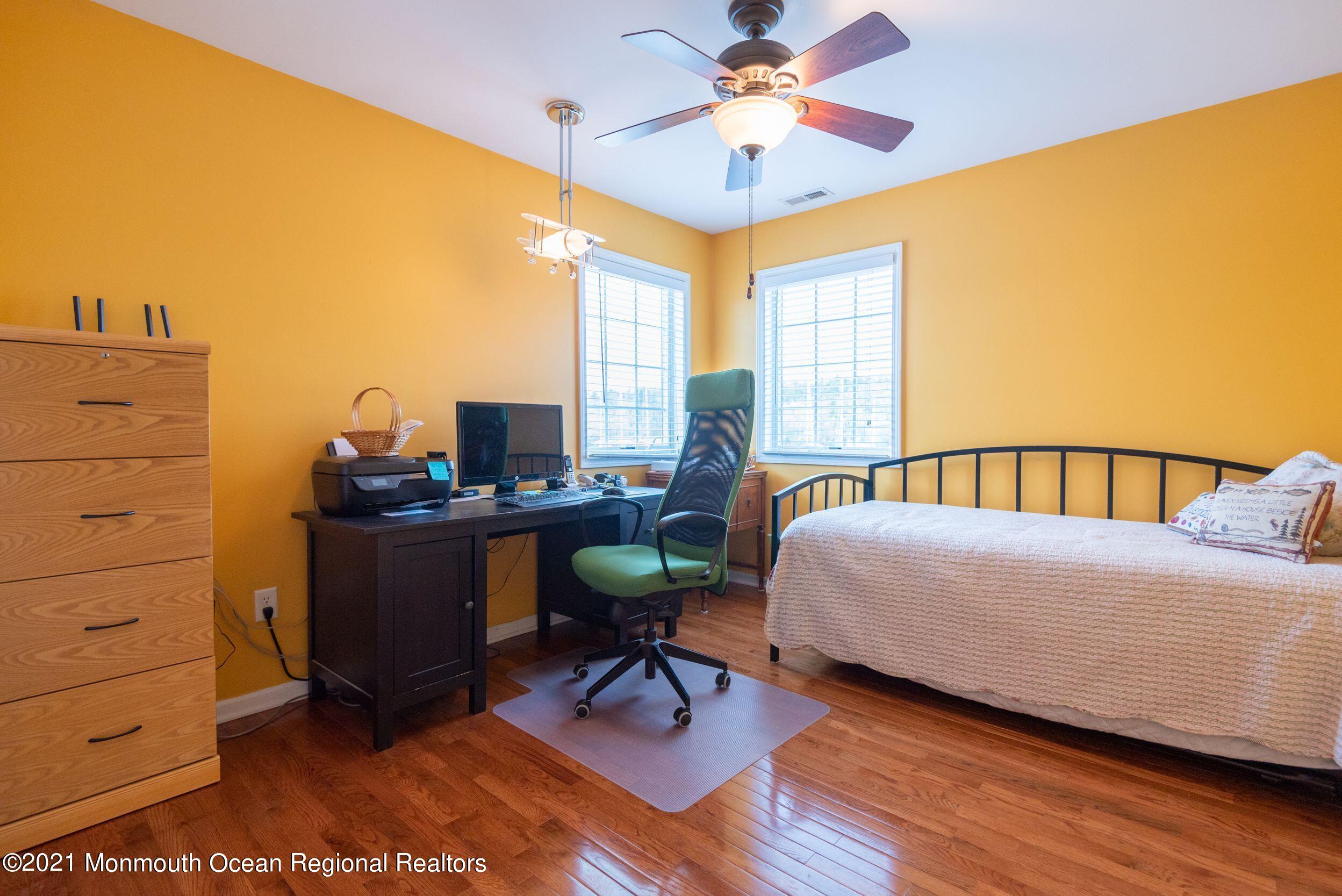 94 Cedar Run Road Bayville, NJ 08721 - Photo 28 of 43 a bedroom with a bed and a chandelier