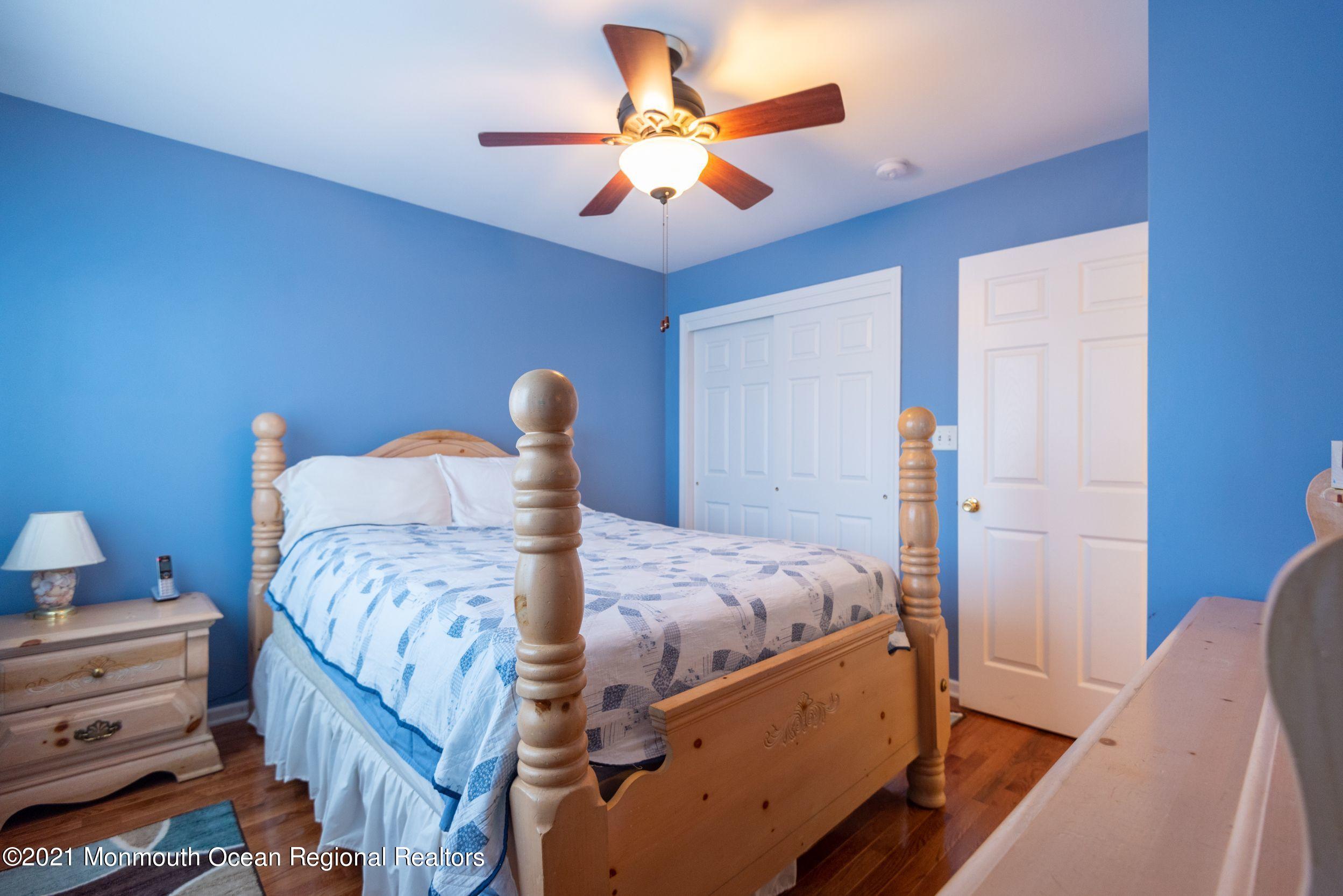 94 Cedar Run Road Bayville, NJ 08721 - Photo 29 of 43 a bedroom with bed and a chandelier