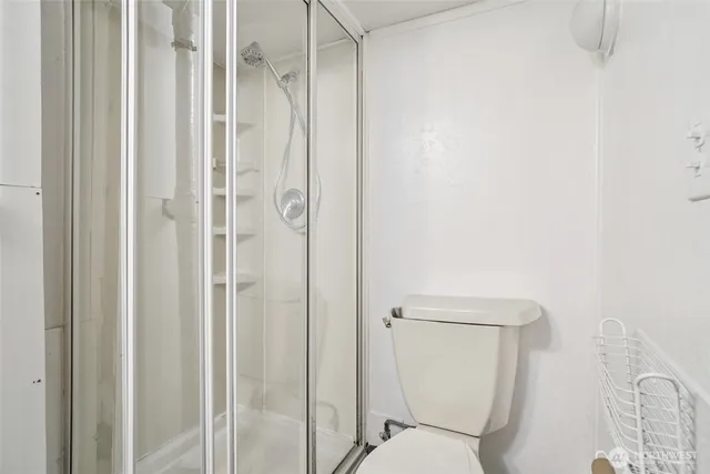 a white toilet sitting next to a shower