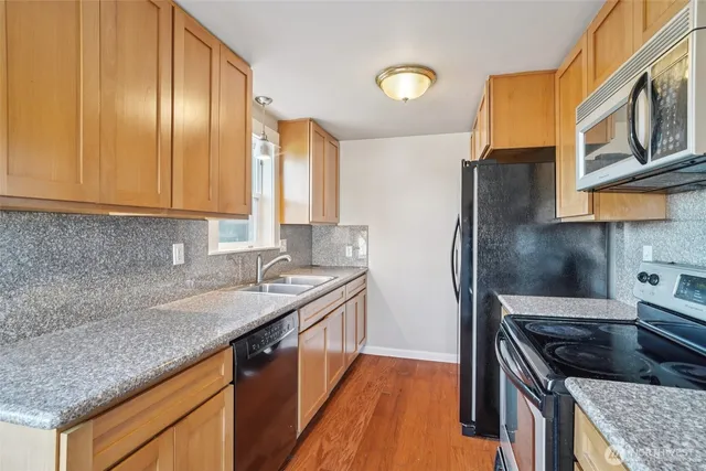 a kitchen with stainless steel appliances granite countertop a sink stove and refrigerator