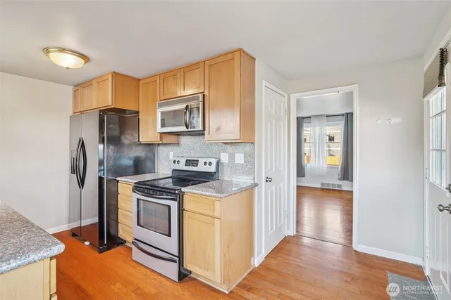 a kitchen with stainless steel appliances granite countertop a stove a refrigerator and a sink