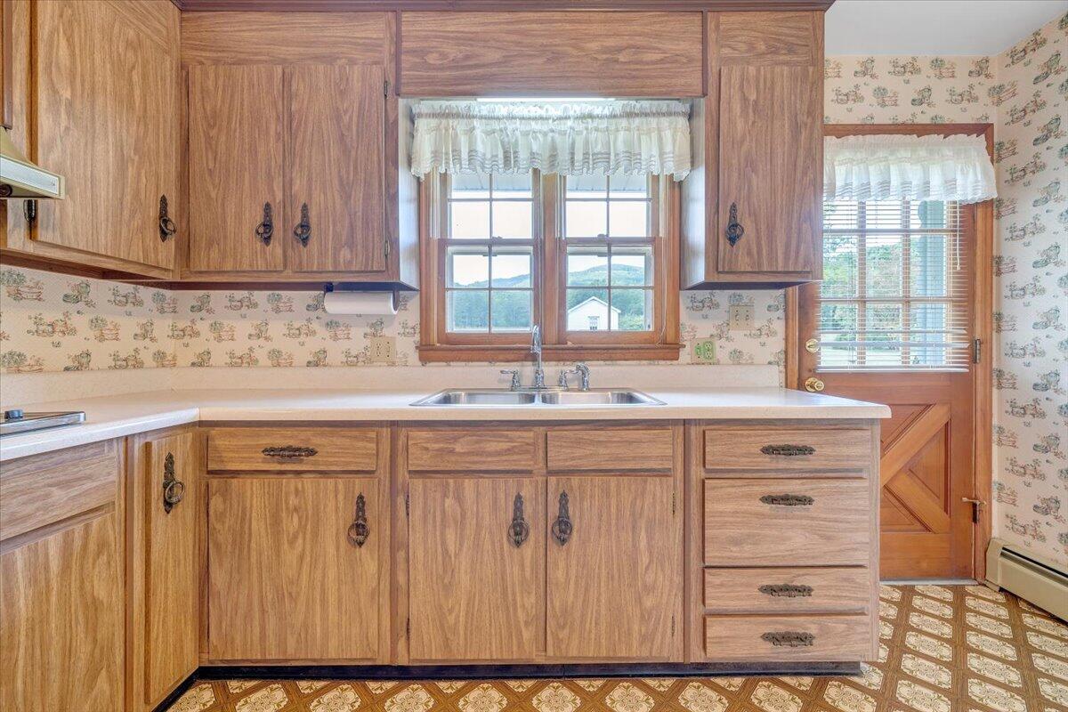 2324 Camp Jaycee Road Blue Ridge, VA 24064 - Photo 18 of 74 a kitchen with granite countertop white cabinets and sink