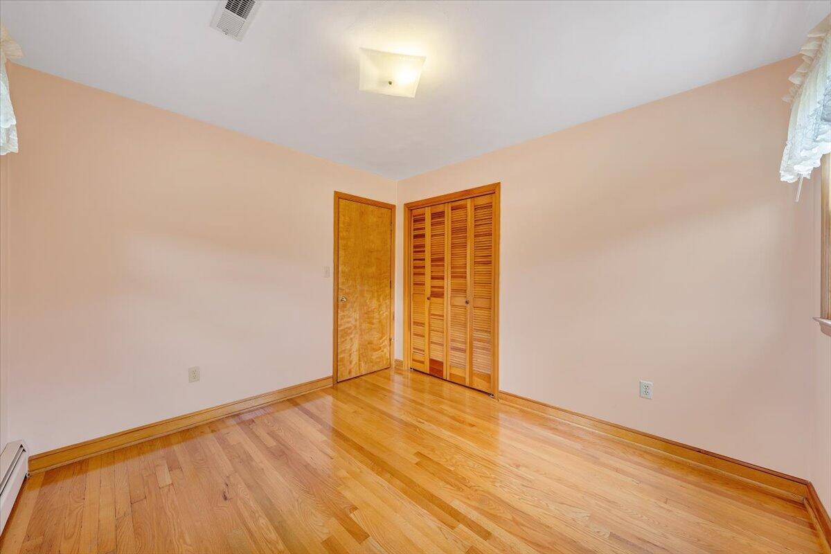 2324 Camp Jaycee Road Blue Ridge, VA 24064 - Photo 34 of 74 an empty room with wooden floor and natural light