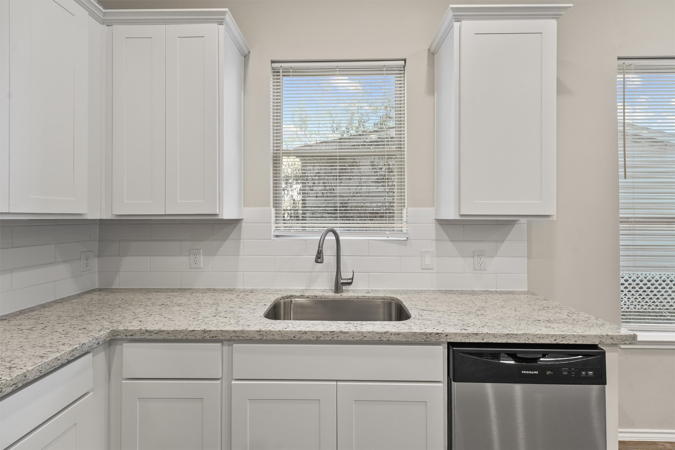 8687 Sassafras Willis, TX 77318 - Photo 13 of 32 a kitchen with granite countertop white cabinets and window
