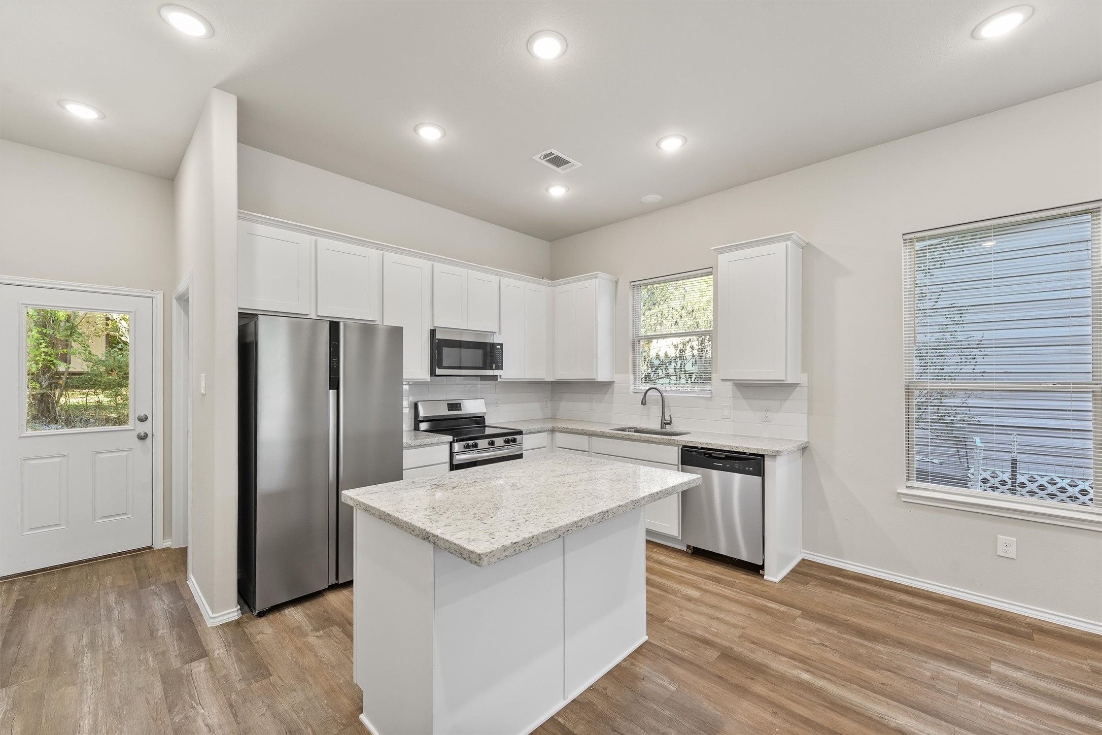 8687 Sassafras Willis, TX 77318 - Photo 9 of 32 a kitchen with refrigerator cabinets and wooden floor