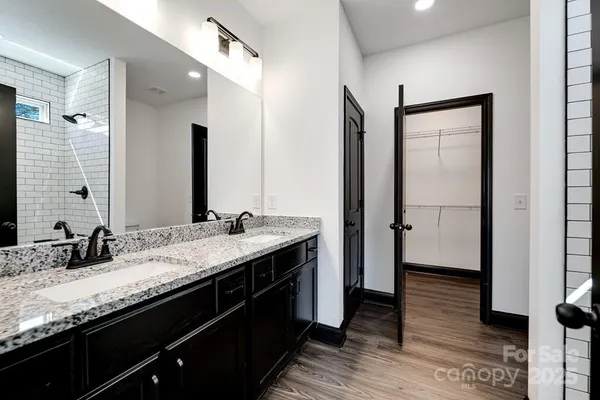 a bathroom with a granite countertop double vanity sink and a mirror
