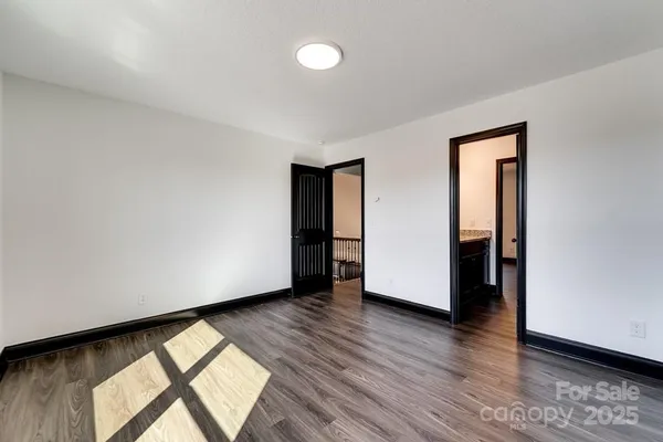 an empty room with wooden floor and a window