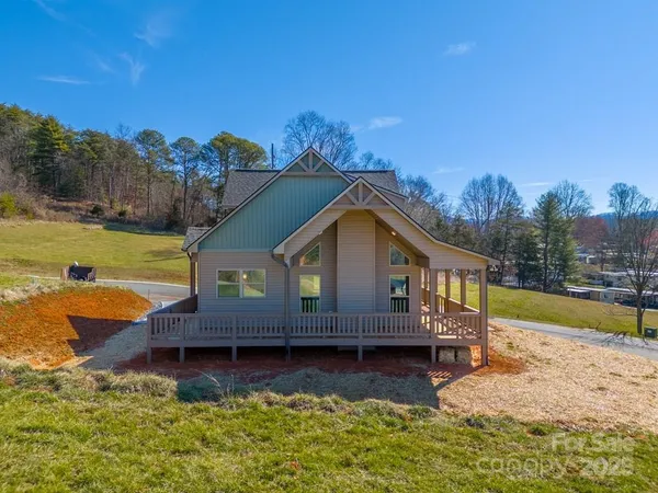 a view of a house with swimming pool next to a yard