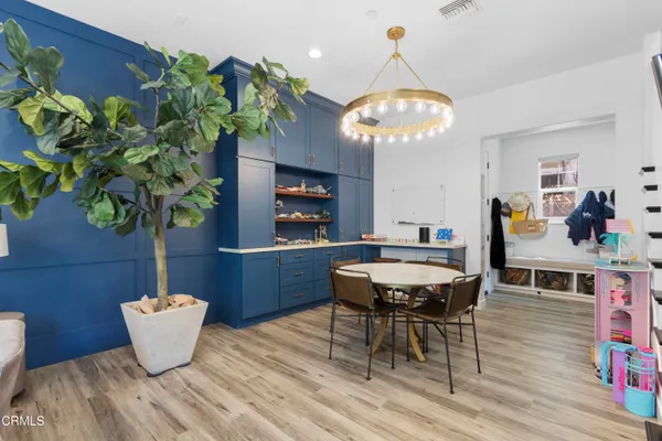 a living room with furniture a chandelier and a potted plant