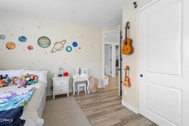 a bedroom with a large bed a large window with table and chairs