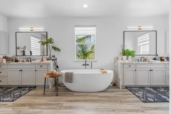 a spacious bathroom with a tub sink and mirror