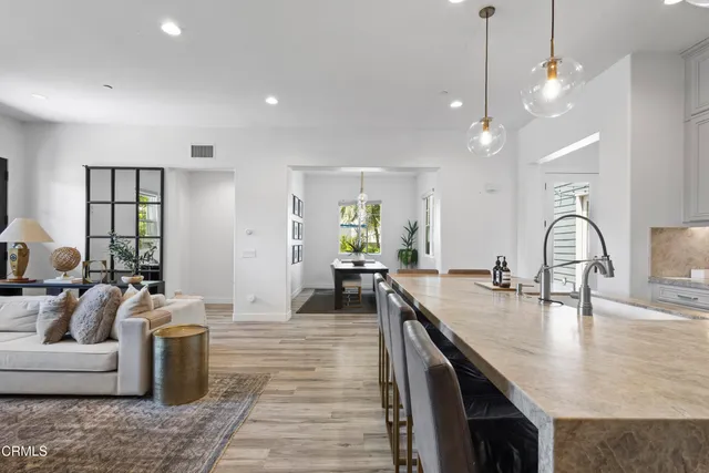 a kitchen with stainless steel appliances granite countertop a sink a stove and a wooden floors