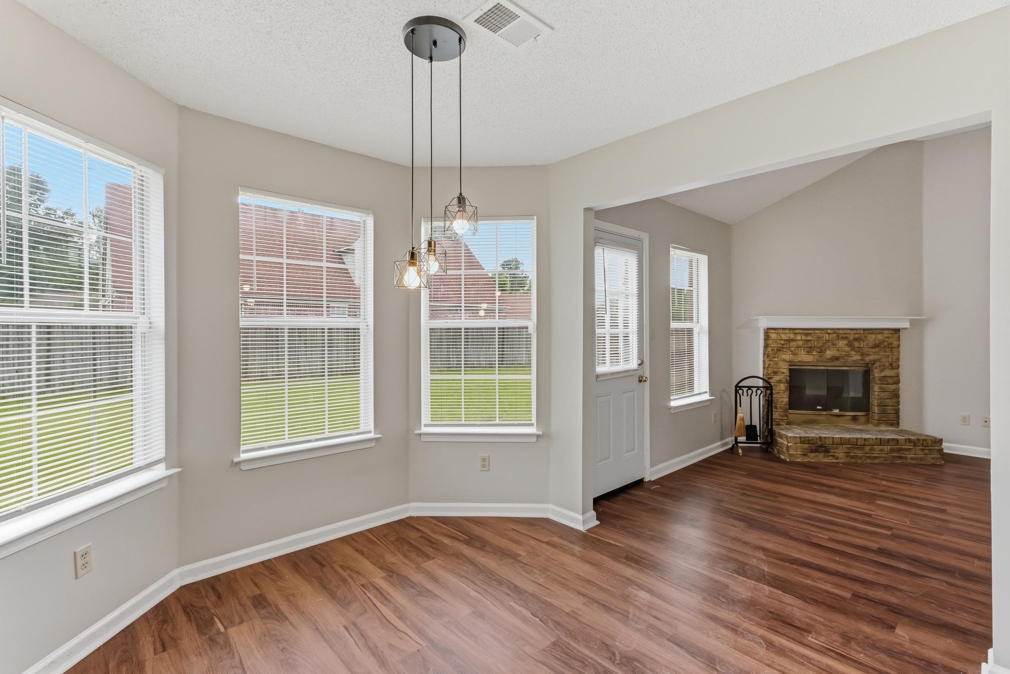 4101 Long Creek Road Memphis, TN 38125 - Photo 7 of 36 Wood-finish flooring throughout, complemented by a contemporary three-light pendant fixture