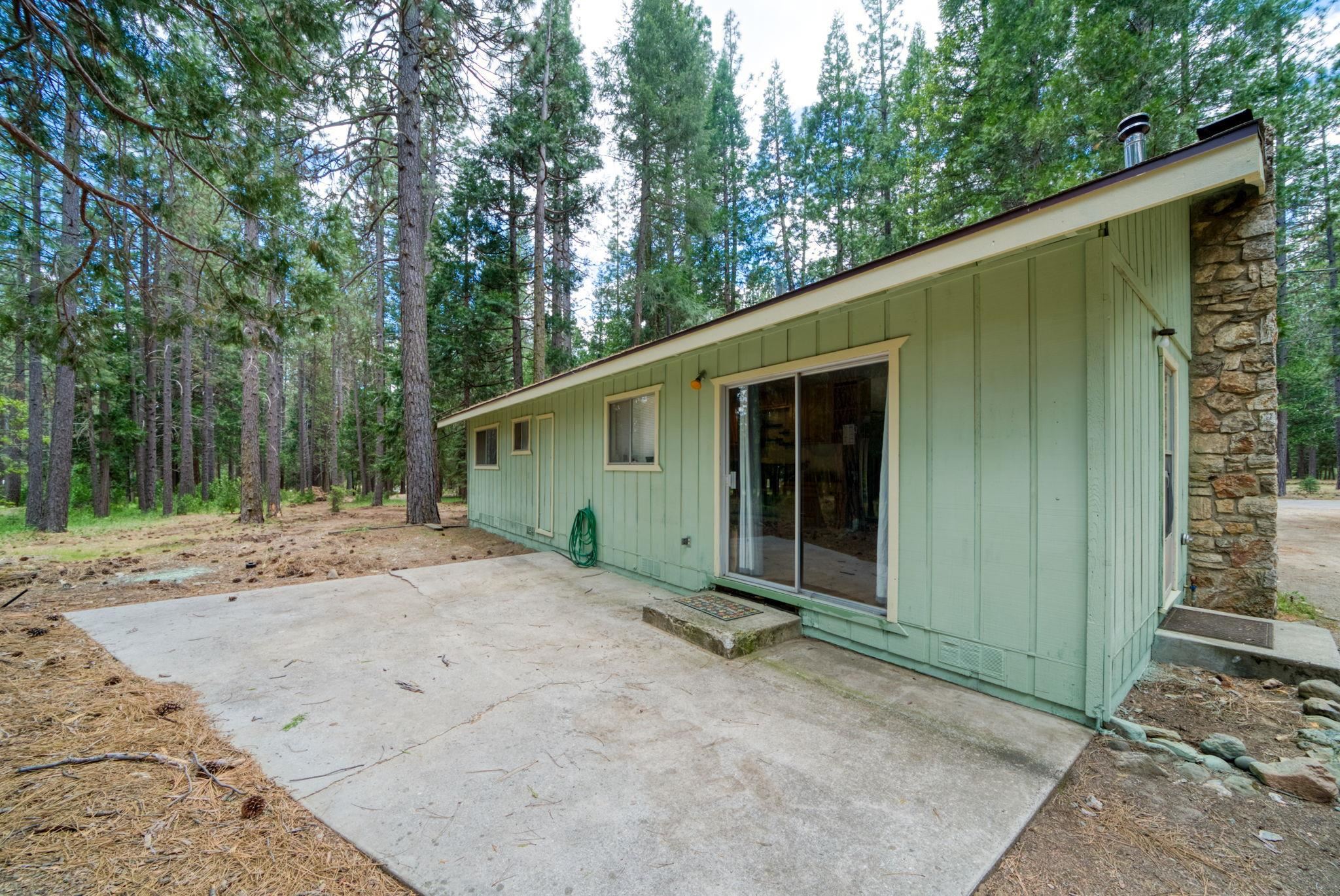 58374 Gill Ranch Road Cromberg, CA 96103 - Photo 19 of 44 a backyard of a house with large trees and outdoor seating