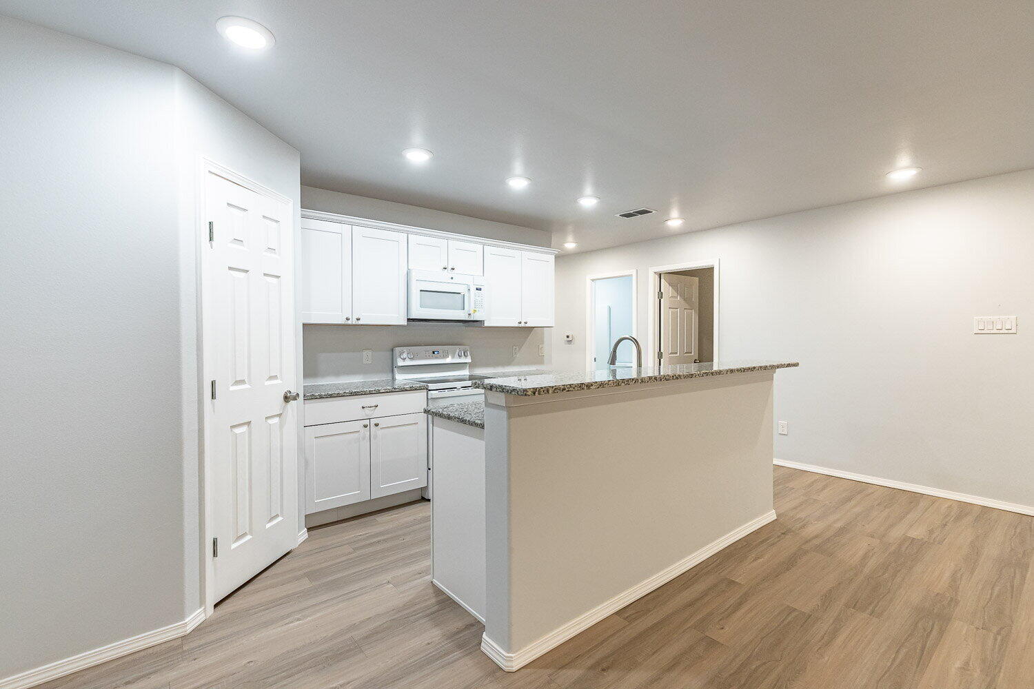 5517 Kemper Street, Unit A Lubbock, TX 79416 - Photo 11 of 25 a kitchen with stainless steel appliances granite countertop a refrigerator sink and white cabinets