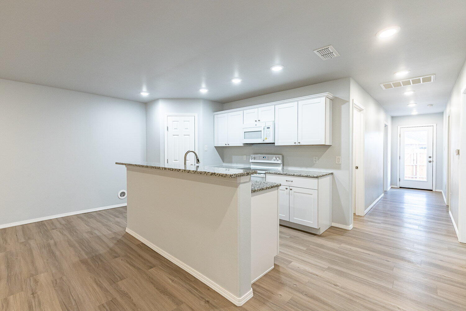 5517 Kemper Street, Unit A Lubbock, TX 79416 - Photo 4 of 25 a view of kitchen with granite countertop refrigerator oven sink and white cabinets with wooden floor