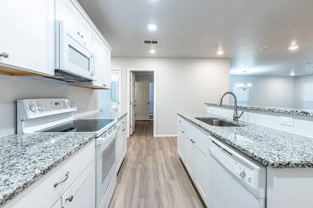 a kitchen with stainless steel appliances granite countertop a sink stove and refrigerator