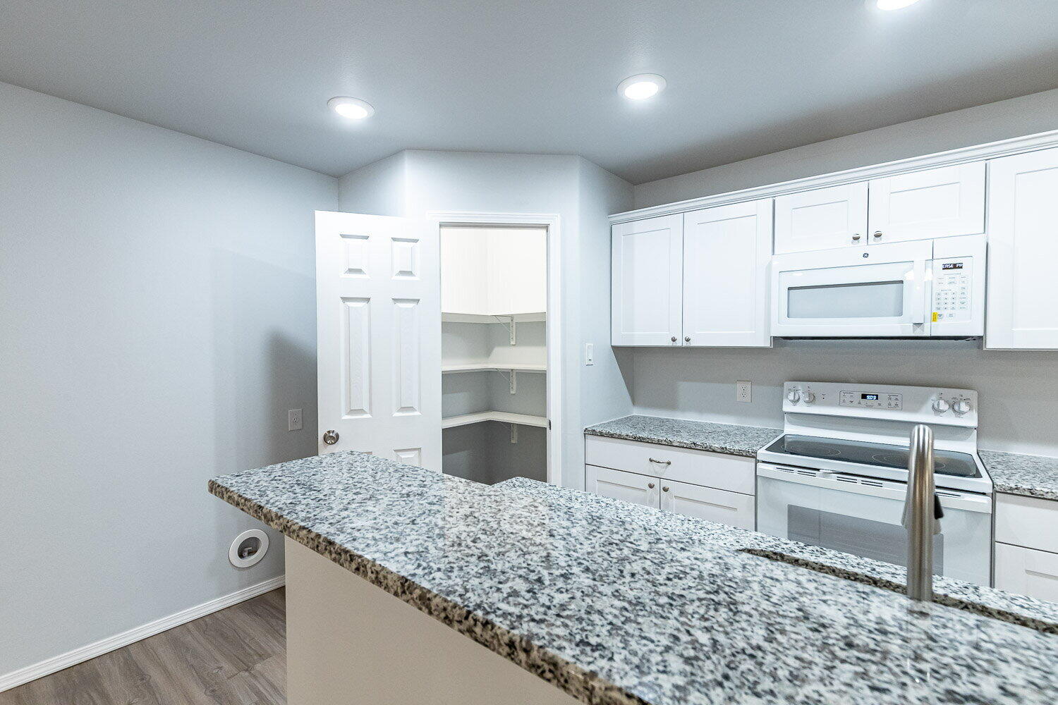 5517 Kemper Street, Unit A Lubbock, TX 79416 - Photo 7 of 25 a kitchen with stainless steel appliances granite countertop a stove a sink and a refrigerator