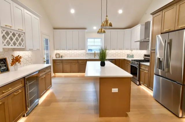 a kitchen with stainless steel appliances granite countertop a refrigerator a sink a stove and a refrigerator