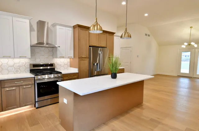 a kitchen with kitchen island a sink stainless steel appliances and cabinets