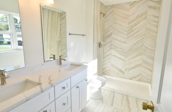 a bathroom with a granite countertop sink a toilet and shower