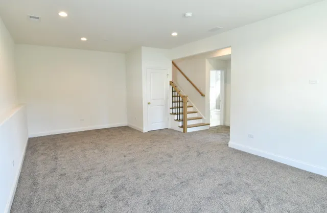 an empty room with stairs and white walls