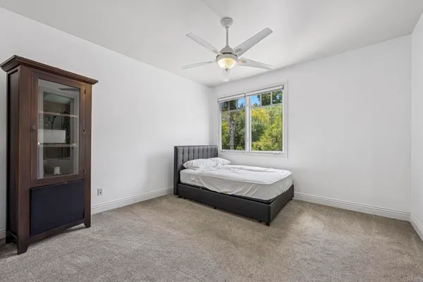 an empty room with a ceiling fan and a window