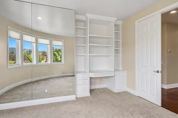 an empty room with windows and ceiling fan