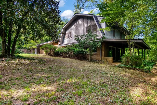 a front view of house with yard and trees around