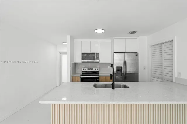 a kitchen with stainless steel appliances a refrigerator and a stove top oven