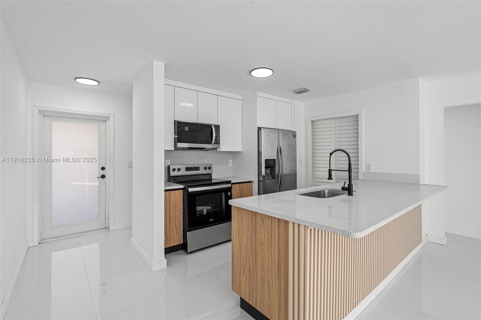 3956 Northwest 207 St Road Miami Gardens, FL 33055 - Photo 12 of 36 a kitchen with stainless steel appliances granite countertop a sink a stove a refrigerator a microwave and island