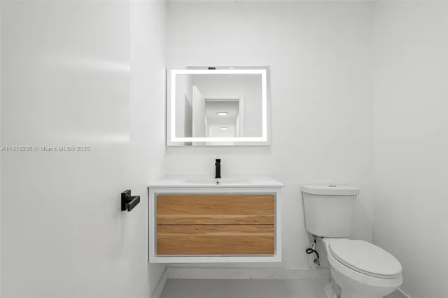 a bathroom with a toilet a sink and mirror
