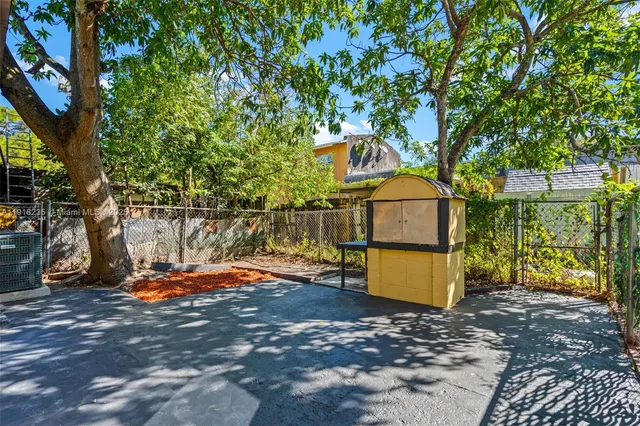 a backyard of a house with barbeque oven table and chairs