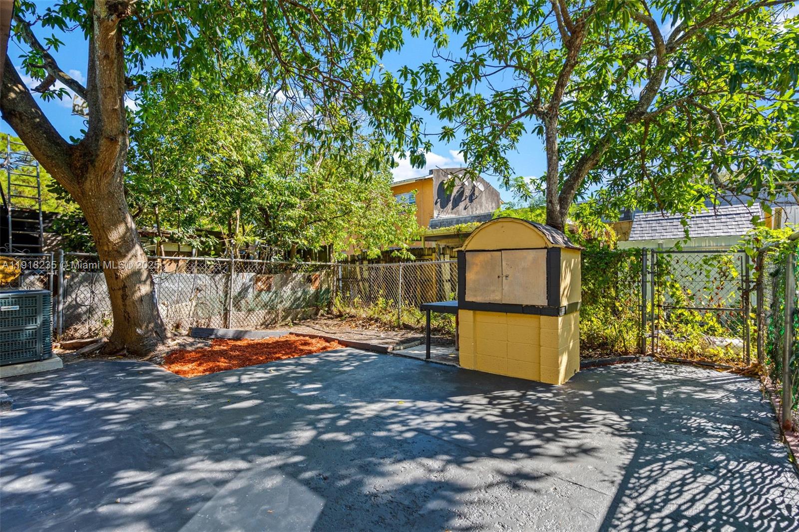 3956 Northwest 207 St Road Miami Gardens, FL 33055 - Photo 30 of 36 a backyard of a house with barbeque oven table and chairs
