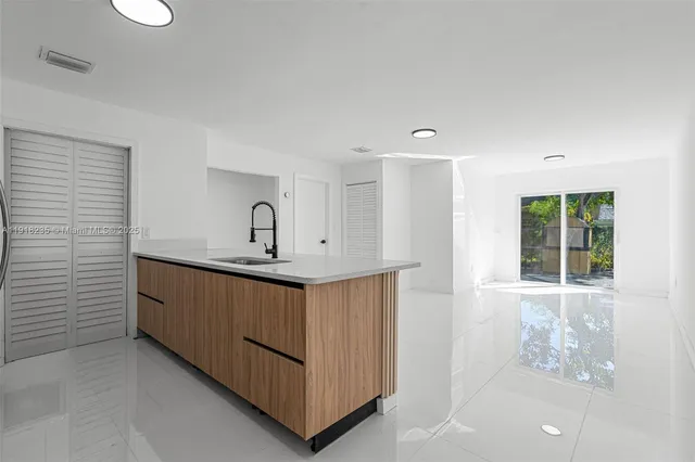 a room with a sink a window and chandelier