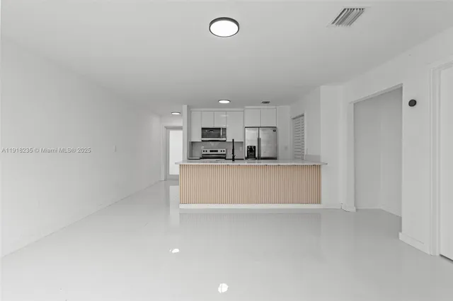a view of kitchen with refrigerator sink and cabinets